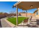 Covered patio and outdoor seating area with low maintenance desert landscaping at 25797 W St Charles Ct, Buckeye, AZ 85326