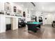 Large living room featuring a billiard table, decor shelving, and tile floors at 25797 W St Charles Ct, Buckeye, AZ 85326