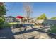 Enjoy the backyard with gravel, patio seating, red umbrella and green lawn area at 2719 N Greenfield Rd, Phoenix, AZ 85006