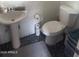 Cozy bathroom featuring a pedestal sink, toilet, and pebble tile flooring at 2719 N Greenfield Rd, Phoenix, AZ 85006