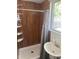 Bathroom showcasing a shower with wood-look paneling and a sink with window view at 2719 N Greenfield Rd, Phoenix, AZ 85006