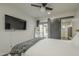 Main bedroom with a sliding barn door to outside, ceiling fan, and a wall-mounted television at 2719 N Greenfield Rd, Phoenix, AZ 85006