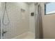 Bright white tiled tub-shower combination with storage alcove and mounted shower product dispensers at 2719 N Greenfield Rd, Phoenix, AZ 85006