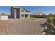 Home's backyard features a rock landscape, grass patch, covered patio, and privacy fence at 3023 W Quail Ave, Phoenix, AZ 85027