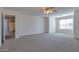 Spacious carpeted bedroom featuring a ceiling fan, large window, and a view into the bathroom at 3023 W Quail Ave, Phoenix, AZ 85027