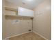 Practical laundry room with overhead cabinets and shelving offers efficiency and organization at 3023 W Quail Ave, Phoenix, AZ 85027