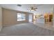 Spacious living room featuring carpet flooring and an open layout to the kitchen and dining area at 3023 W Quail Ave, Phoenix, AZ 85027