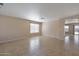 Open living room with tile flooring, a window, and an arched doorway leading to another room at 3023 W Quail Ave, Phoenix, AZ 85027