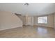 Open-concept living room featuring tile flooring, staircase, and a window providing natural light at 3023 W Quail Ave, Phoenix, AZ 85027