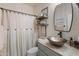 Stylish bathroom featuring a vessel sink, open shelving, decorative mirror and textured shower curtain at 31061 N 136Th Ln, Peoria, AZ 85383