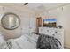 Bright bedroom featuring tile floors, a black metal bed frame, and a white dresser with round mirror at 31061 N 136Th Ln, Peoria, AZ 85383