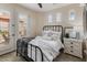 Bright bedroom featuring tile floors, a black metal bed frame, and access to an outdoor patio at 31061 N 136Th Ln, Peoria, AZ 85383