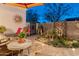 Charming outdoor patio with travertine tile, a sunburst decoration, and well-maintained garden area at 31061 N 136Th Ln, Peoria, AZ 85383