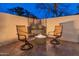 Cozy outdoor patio featuring two chairs and a fire pit at twilight at 31061 N 136Th Ln, Peoria, AZ 85383