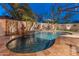 Serene pool view with seating area, water feature, and desert landscaping at twilight at 31061 N 136Th Ln, Peoria, AZ 85383