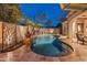 Inviting backyard pool with lush landscaping, a waterfall feature, and shaded seating at 31061 N 136Th Ln, Peoria, AZ 85383