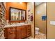 Bathroom featuring decorative stone wall, granite counters, wood cabinets and tile floor at 31816 N 19Th Ave, Phoenix, AZ 85085