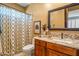 Bathroom vanity featuring wood cabinets, granite counters and framed mirror at 31816 N 19Th Ave, Phoenix, AZ 85085