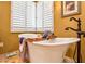 Elegant bathtub featuring a bronze faucet and a wooden tray, perfect for relaxing at 31816 N 19Th Ave, Phoenix, AZ 85085