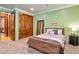 Bedroom featuring plush carpet, an accent wall, wood doors and trim at 31816 N 19Th Ave, Phoenix, AZ 85085