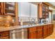 Elegant kitchen counter with stainless steel sink, a window view, and wooden cabinets at 31816 N 19Th Ave, Phoenix, AZ 85085