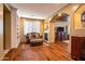 Cozy living room with fireplace, built-in shelving, shuttered windows, and hardwood floors at 31816 N 19Th Ave, Phoenix, AZ 85085