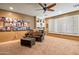 Cozy living room featuring white window shutters, a ceiling fan, and built-in shelves at 31816 N 19Th Ave, Phoenix, AZ 85085