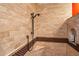 Walk-in shower featuring travertine tile, decorative trim, built-in bench and niche for toiletries at 31816 N 19Th Ave, Phoenix, AZ 85085