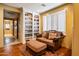 Cozy sitting room featuring a comfortable sofa, built-in bookshelves, and plantation shutters at 31816 N 19Th Ave, Phoenix, AZ 85085