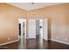 A bedroom featuring tan walls, wood floors, and 3 doors at 3311 W Baylor Ln, Chandler, AZ 85226