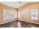 This bedroom features wood floors, tan walls and 3 windows with matching white wood shutters at 3311 W Baylor Ln, Chandler, AZ 85226