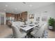 Dining area with a marble table, seating for six, and kitchen in the background at 34283 N Sandpiper Trl, Queen Creek, AZ 85144