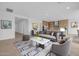 Bright, airy living room with comfortable seating, decor, and a view into the kitchen at 34283 N Sandpiper Trl, Queen Creek, AZ 85144