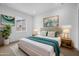 Bright main bedroom featuring a large bed with a turquoise throw, white walls, and neutral-toned nightstands at 34283 N Sandpiper Trl, Queen Creek, AZ 85144