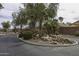 Landscaped entrance of The Village at Grande Valley Ranch with a rock water feature and palm trees at 3864 W Fairway Dr, Eloy, AZ 85131