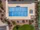 Overhead shot of a pool with a blue cover, featuring desert landscaping and surrounding palm trees at 3864 W Fairway Dr, Eloy, AZ 85131