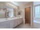 Well-lit bathroom features double sinks, tile floors, a window, and a door leading to the bathtub and shower at 4228 E Desert Sky Ct, Cave Creek, AZ 85331