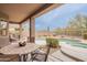 Covered patio with dining area overlooking a free-form pool, spa, and desert landscaping at 4228 E Desert Sky Ct, Cave Creek, AZ 85331