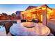 Backyard dining area with large table near pool and outdoor living space at twilight at 42829 W Oakland Dr, Maricopa, AZ 85138