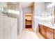 Bright bathroom featuring a tiled walk-in shower, double sink vanity, and entry to walk-in closet at 42829 W Oakland Dr, Maricopa, AZ 85138