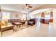 Spacious living room flowing into the kitchen, with a comfortable leather sectional and tile flooring at 42829 W Oakland Dr, Maricopa, AZ 85138