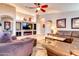 Bright living room featuring a stylish entertainment center with a fireplace and comfortable seating at 42829 W Oakland Dr, Maricopa, AZ 85138