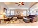 Inviting living room featuring a comfortable leather sectional, ceiling fan, and neutral decor at 42829 W Oakland Dr, Maricopa, AZ 85138