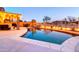 Beautiful pool with custom lighting, landscaping, and a covered patio dining area at 42829 W Oakland Dr, Maricopa, AZ 85138