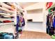 Spacious walk-in closet featuring ample shelving, hanging rods, and carpeted floors at 42829 W Oakland Dr, Maricopa, AZ 85138