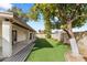 Lush backyard with well-maintained artificial grass and covered patio with grey deck at 4312 W Paradise Dr, Glendale, AZ 85304