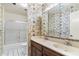 Bathroom with a vintage wallpaper, double sink vanity, and a shower-tub combination at 4312 W Paradise Dr, Glendale, AZ 85304