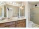 Bathroom with double sink vanity, patterned wallpaper, and a glass-enclosed shower at 4312 W Paradise Dr, Glendale, AZ 85304