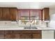 Cozy kitchen with stainless steel sink, white countertops, and wood cabinetry at 4312 W Paradise Dr, Glendale, AZ 85304