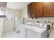 Functional laundry room featuring appliances and overhead cabinets for storage at 4312 W Paradise Dr, Glendale, AZ 85304